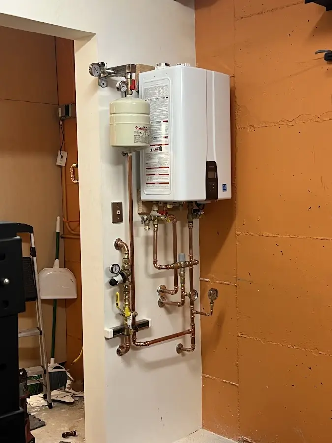 Plumbing technician inspecting water heater connections in Smithtown
